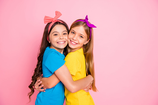Portrait of lovely kids, have free time vacation fun isolated over pink background