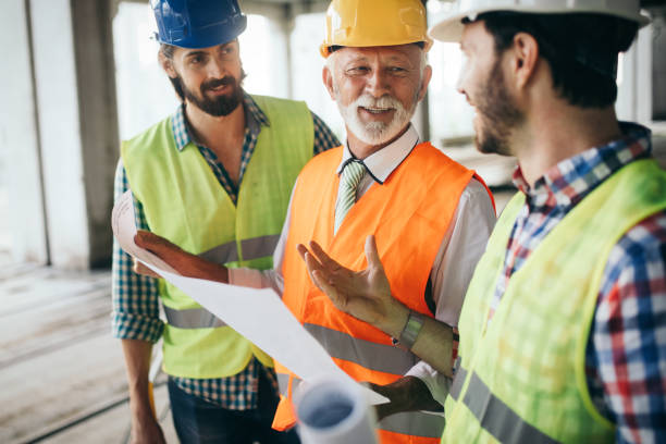 istock Engineer, foreman and worker discussing in building construction site 1159972160