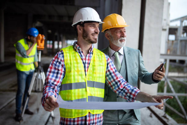 istock Confident team of architects and engineers working together on construction site 1159972339