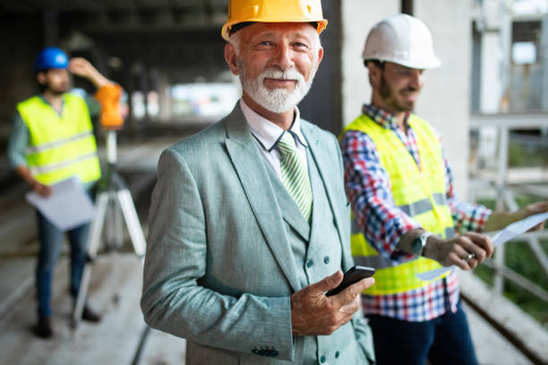 istock Confident construction engineer, architect, businessman in hardhat on building site 1159972373