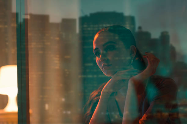 istock Sad beautiful woman sitting next to a window 1159972391