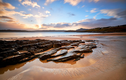 Wonderful beach in Talmine, Scotland. Rocks stick out of the sea. Beautiful sand in the foreground during a sunrise. This beach can be found while driving the north coast 500