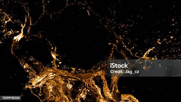 Golden Splashes Isolated On Black Background Stock Photo - Download Image Now - Splashing, Whiskey, Liquid