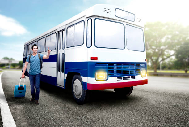 istock Asian man with suitcase bag and backpack standing and pointing a bus on bus station 1159981568