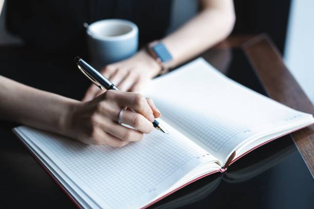 istock Accountant woman checking paperwork while sitting near window in creative office or cafe. Confident young woman working with documents. 1159982602