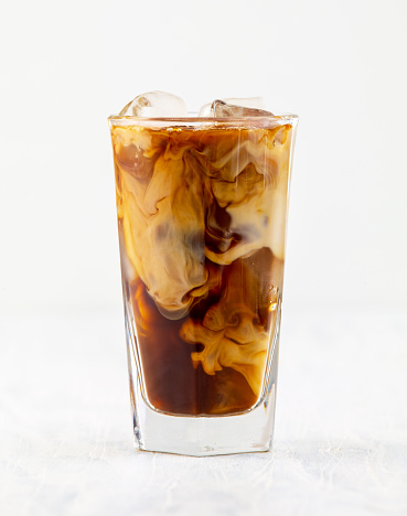 glass of iced coffee with milk on white background
