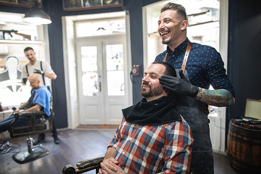 Barber adjusting his customer's head