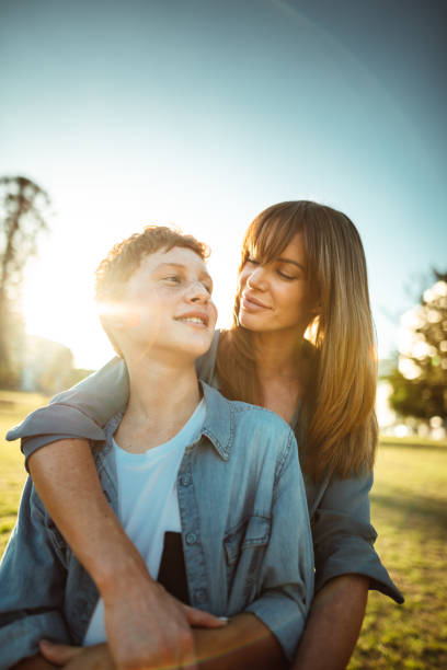 istock teenager embraced with mom consoling her son 1159984162