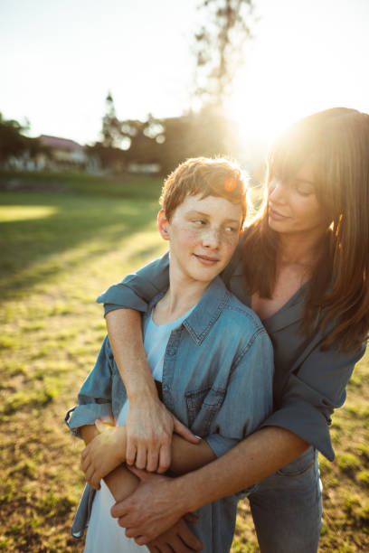 istock teenager embraced with mom consoling her son 1159984227