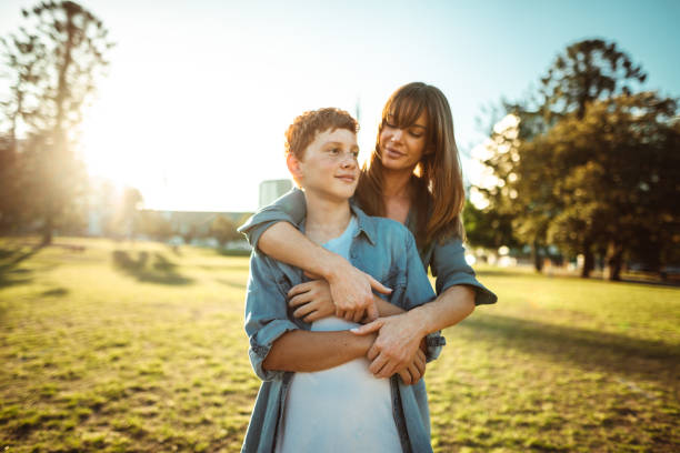 istock teenager embraced with mom consoling her son 1159984288