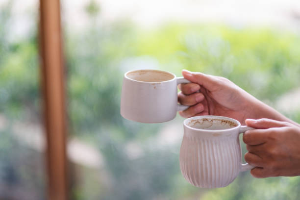 istock hands holding two white cups of hot coffee 1159985482