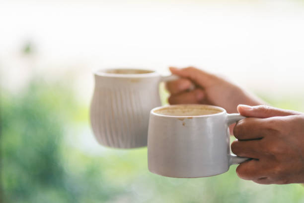 istock hands holding two white cups of hot coffee 1159985509
