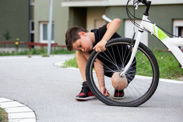 chico triste mirando su neumático de bicicleta plana, niño mirando a la bicicleta con la rueda rota - bicycle chain bicycle gear chain gear fotografías e imágenes de stock