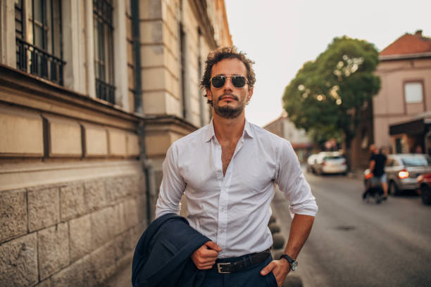 istock Modern gentleman standing on the sidewalk 1159989652