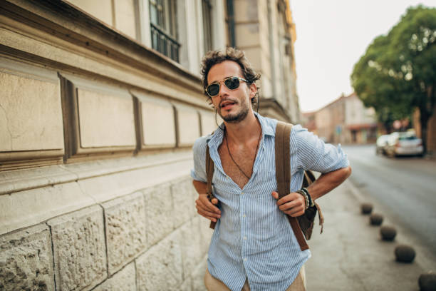 istock Charming guy with backpack on the street 1159990374