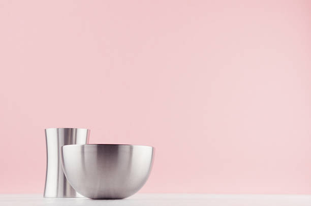 istock Trendy hi-tech decor for interior - elegant silver polished abstract decoration on white wood shelf and soft light pink background. 1159990434