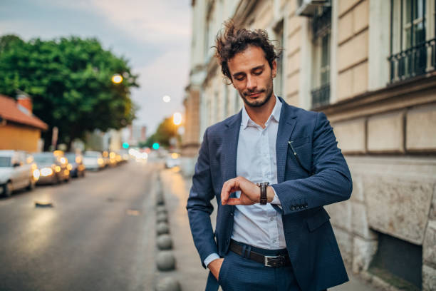 istock Handsome gentleman checking the time on the street 1159991103