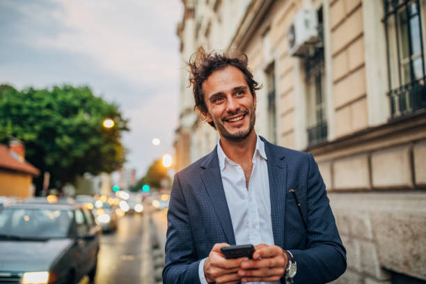 istock Gentleman using mobile on the street 1159991909