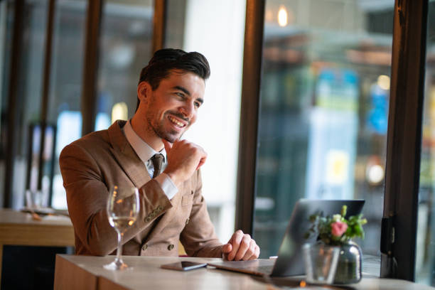 istock Cheerful handsome guy enjoying wine while working in restaurant 1159992346