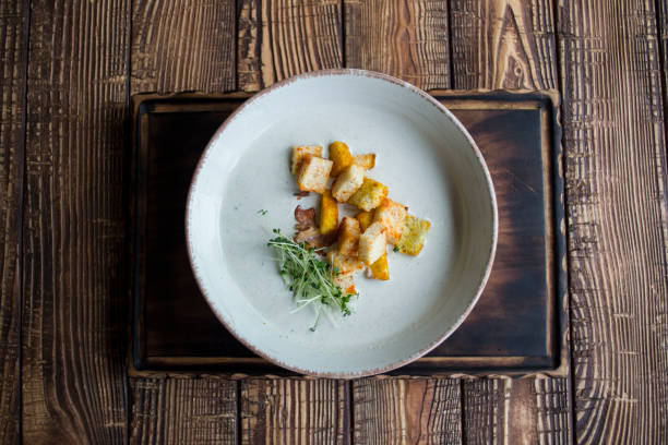 istock Cream soup in a plate, on a wooden table. 1159993279