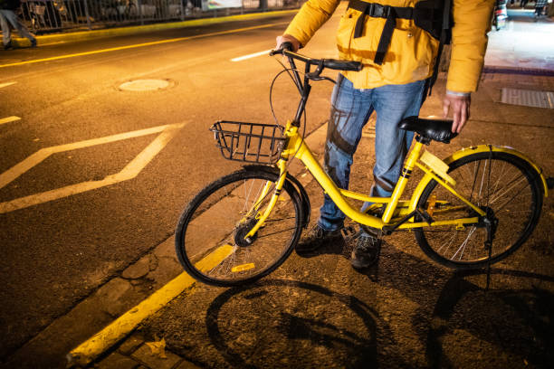 istock Unrecognizable men pushing bicycle on the street at night 1159993340