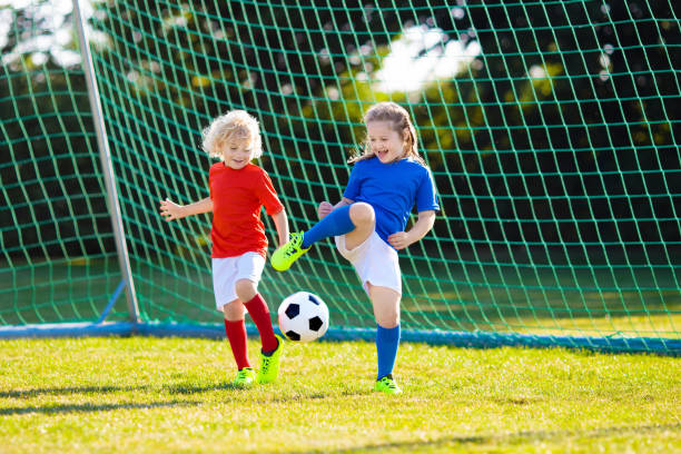 kinder spielen fußball. kind auf dem fußballplatz. - 18633 stock-fotos und bilder