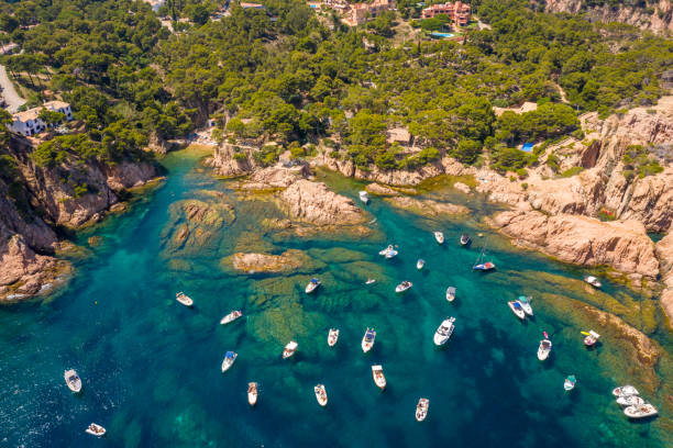 vue aérienne de la baie de plage de aigua xelida avec des bateaux à begur, costa brava, espagne - province de gérone photos et images de collection