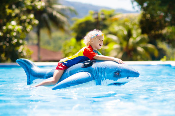 criança na piscina. miúdo no flutuador inflável - 18628 - fotografias e filmes do acervo