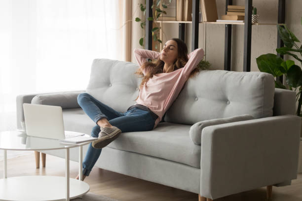 Relaxed woman leaned on couch closed eyes having day nap