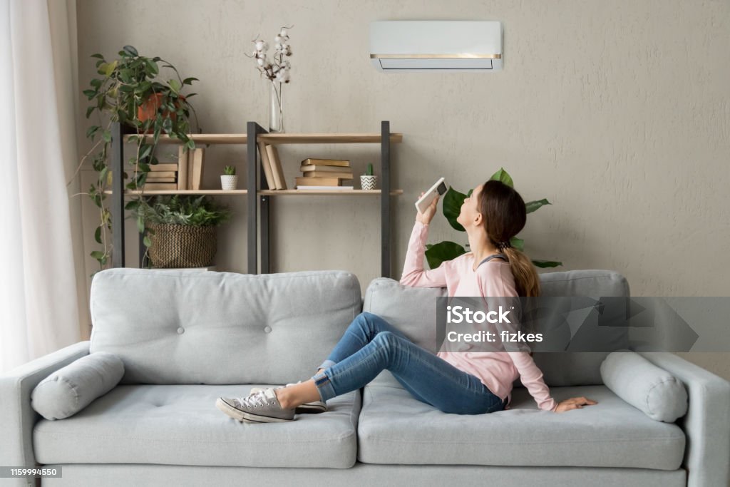 Lycklig kvinna som håller svalare system fjärrkontroll njuta av frisk luft - Royaltyfri Hemliv Bildbanksbilder