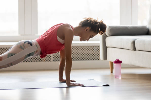 Sportive girl doing push press ups exercise at home Young attractive sportive woman wearing activewear doing push ups or press ups exercise position on sport mat at home, practicing yoga plank pose, working out indoors, healthy active lifestyle concept bodyweight training photos stock pictures, royalty-free photos & images