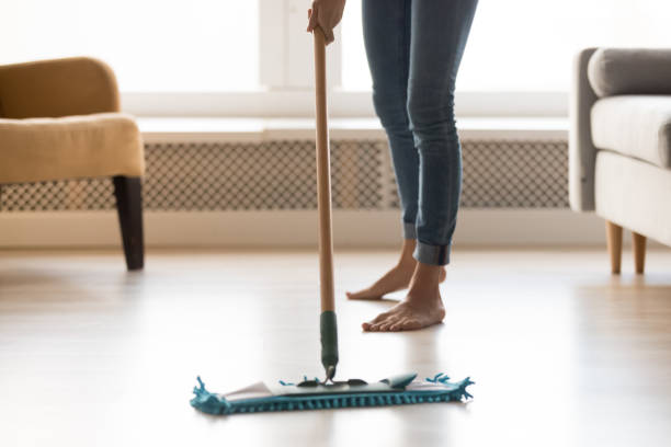 istock Closeup image barefoot girl doing house cleaning using wet mop 1159994590