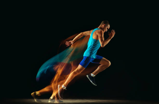 istock Professional male runner training isolated on black studio background in mixed light 1159995338