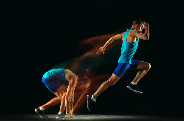 istock Professional male runner training isolated on black studio background in mixed light 1159995374