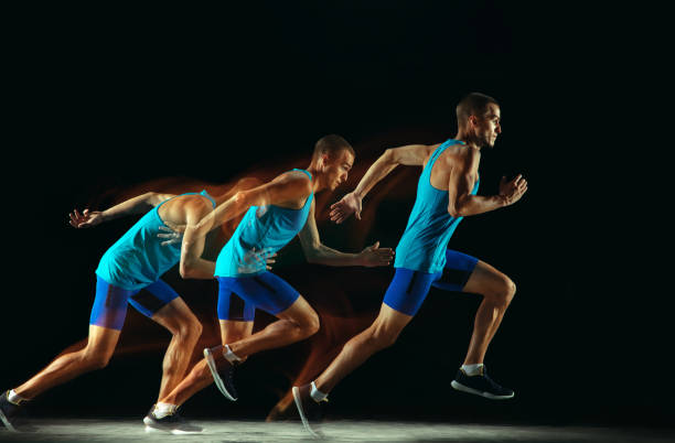 istock Professional male runner training isolated on black studio background in mixed light 1159995381