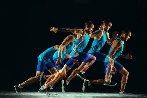 istock Professional male runner training isolated on black studio background in mixed light 1159995382