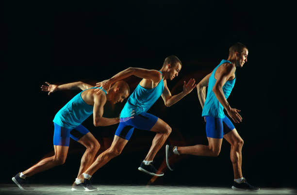 istock Professional male runner training isolated on black studio background in mixed light 1159995383