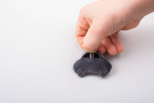 Little car model in toddler hand on white background