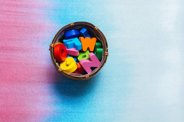 istock Colorful wooden letters in container on a colorful background 1159996178