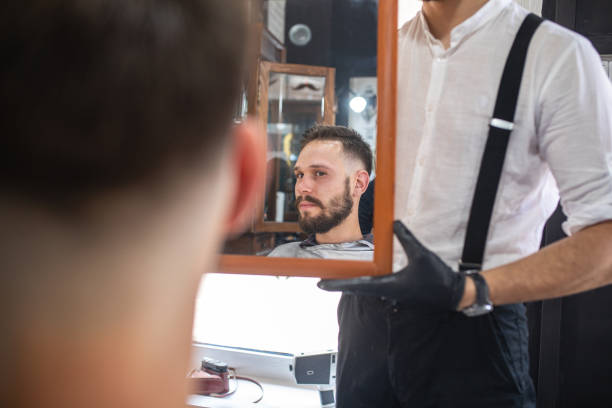 istock Pro hair salon worker holding a mirror for his customer 1159996468