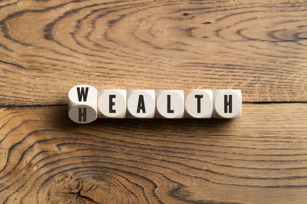 Letters on blocks spelling wealth or health Overhead view on black letters carved on small wooden blocks spelling wealth or health on wood table surface conceptual realism photos stock pictures, royalty-free photos & images