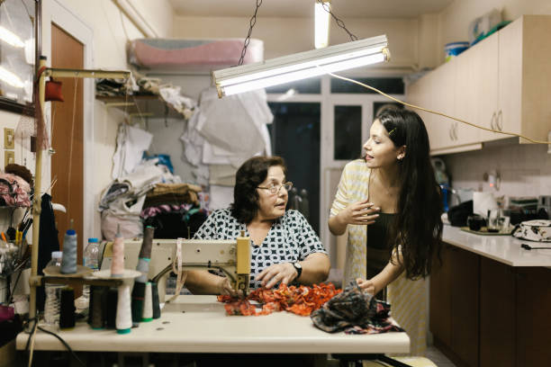 istock Active senior teaches granddaughter how to use sewing machine 1160002887