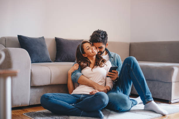 istock Couple looking at mobile phone at home 1160002917