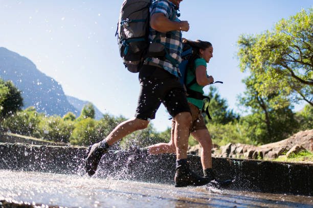 istock Hiking couple crossing a shallow river running 1160003821