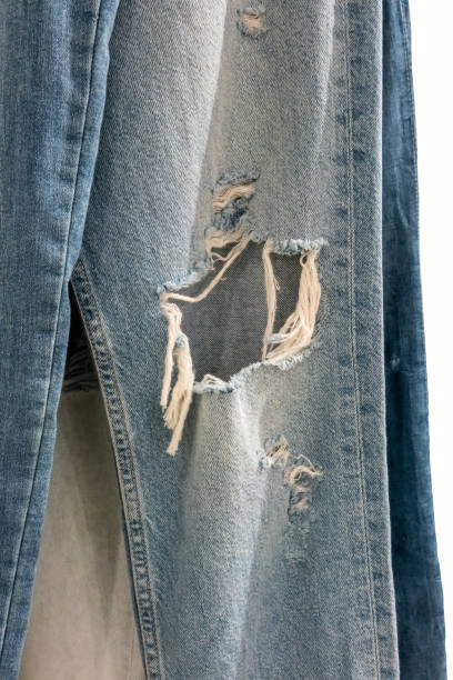 istock Jeans torn hanging for display in store. Jeans torn at the knee close up 1160004889