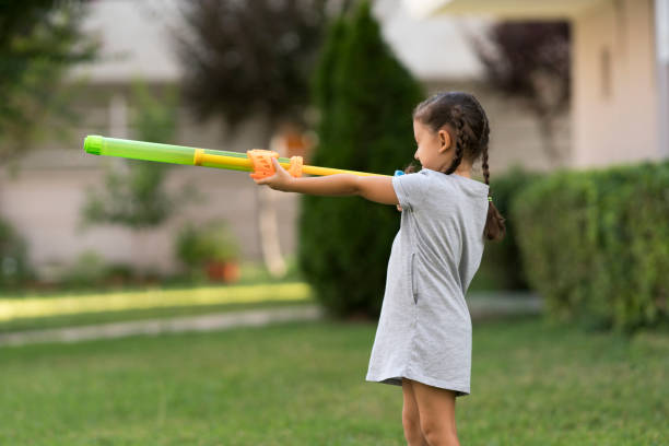 istock Little girl playing with squirt gun 1160006840