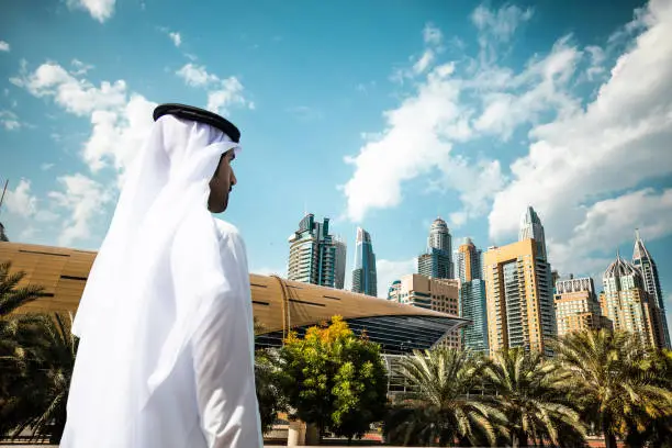 Photo of Sheikh looking to Dubai downtown skyscrapers and office buildings