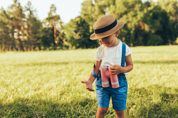 imagen de niño lindo jugando con un binoculares en busca de una imaginación o exploración en el día de verano en el parque. niño feliz jugando al aire libre en el bosque. concepto de infancia - discovery binoculars boy scout searching fotografías e imágenes de stock