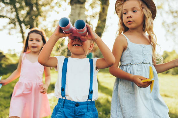 chilldren bawi się lornetką i papierowym samolotem w letni dzień w parku. szczęśliwe dzieci grające udawać safari gra na świeżym powietrzu w lesie. koncepcja dzieciństwa - little boys discovery binoculars child zdjęcia i obrazy z banku zdjęć