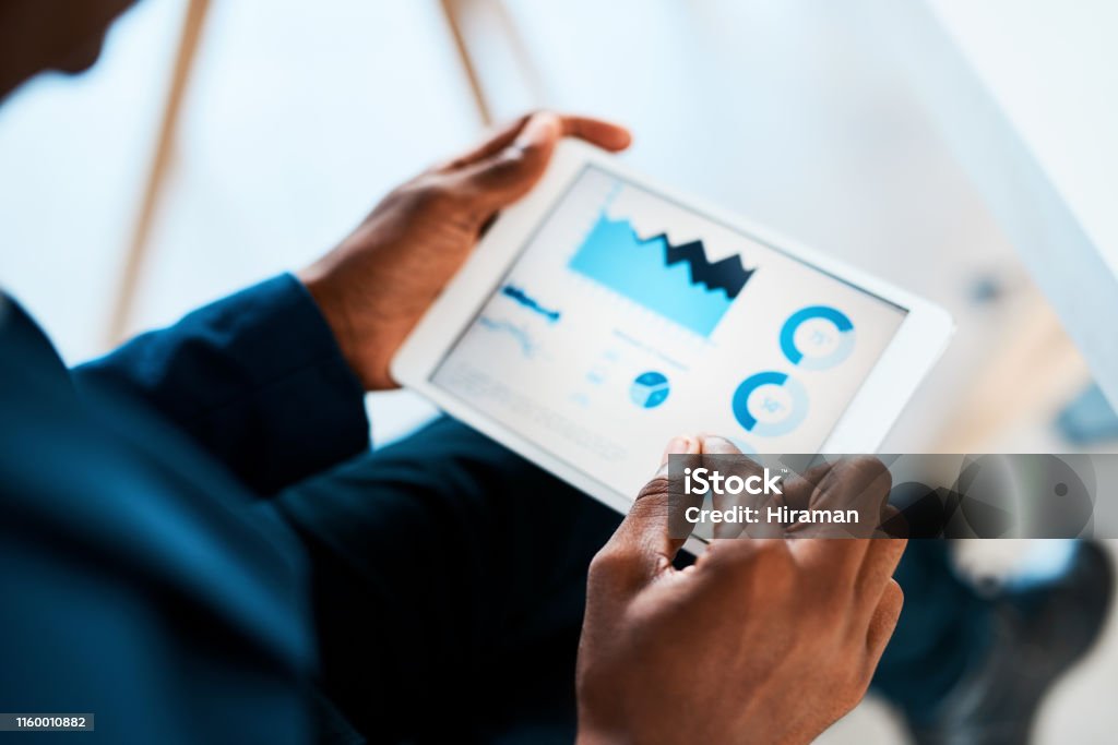 Number crunching just got smarter Cropped shot of a businesswoman using a digital tablet with graphs on it in a modern office Digital Tablet Stock Photo
